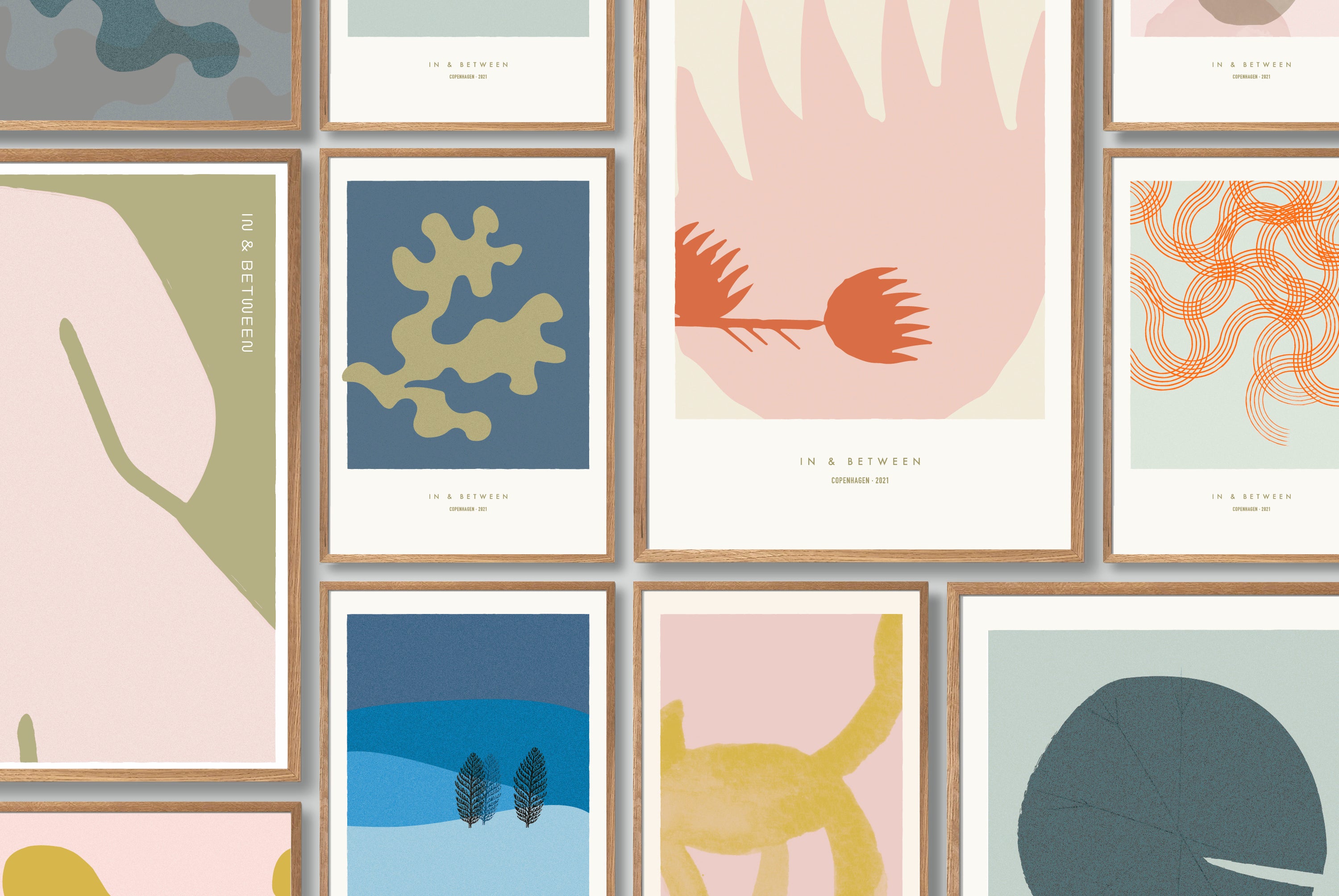 Art wall of natural wood framed fine art prints in various designs from botanicals, small creatures and abstractions on human form, In & Between.