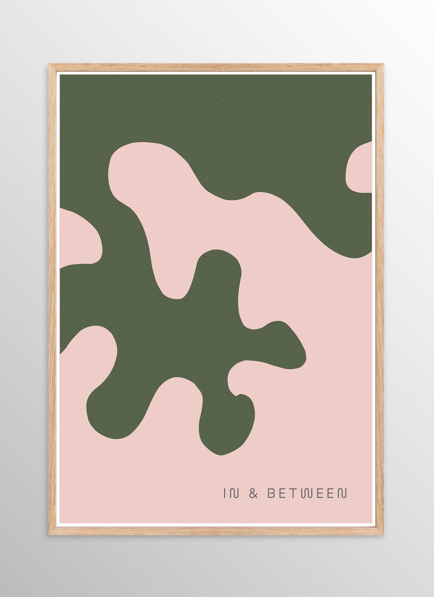 Art print of large forest green oak leaf on soft peach background in natural wooden frame.