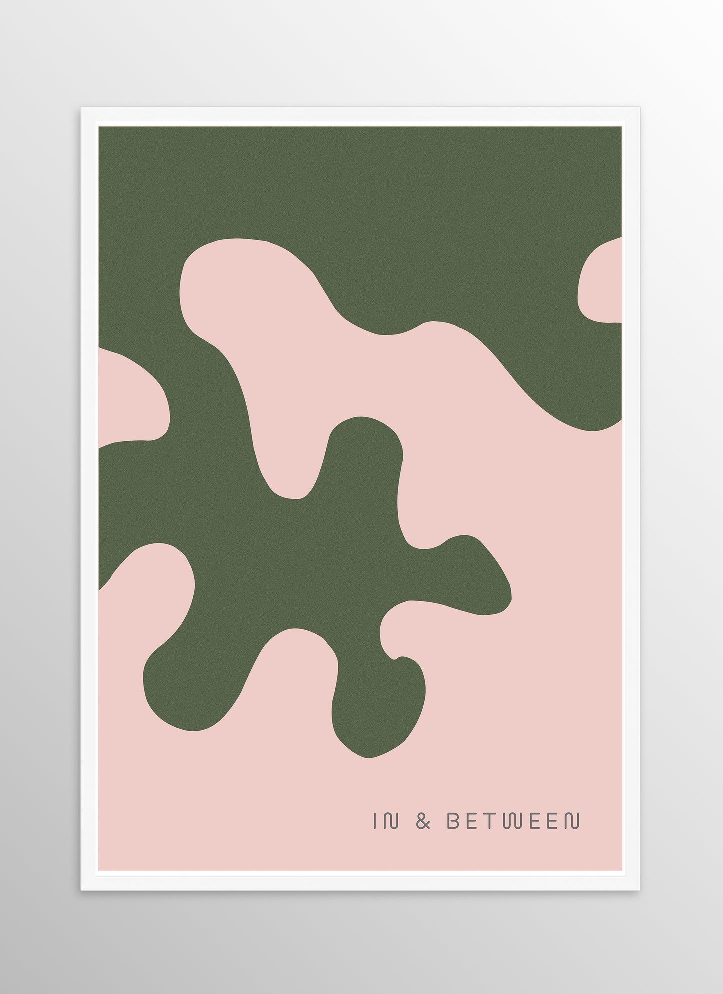 Art print of large forest green oak leaf on soft peach background in white wooden frame.