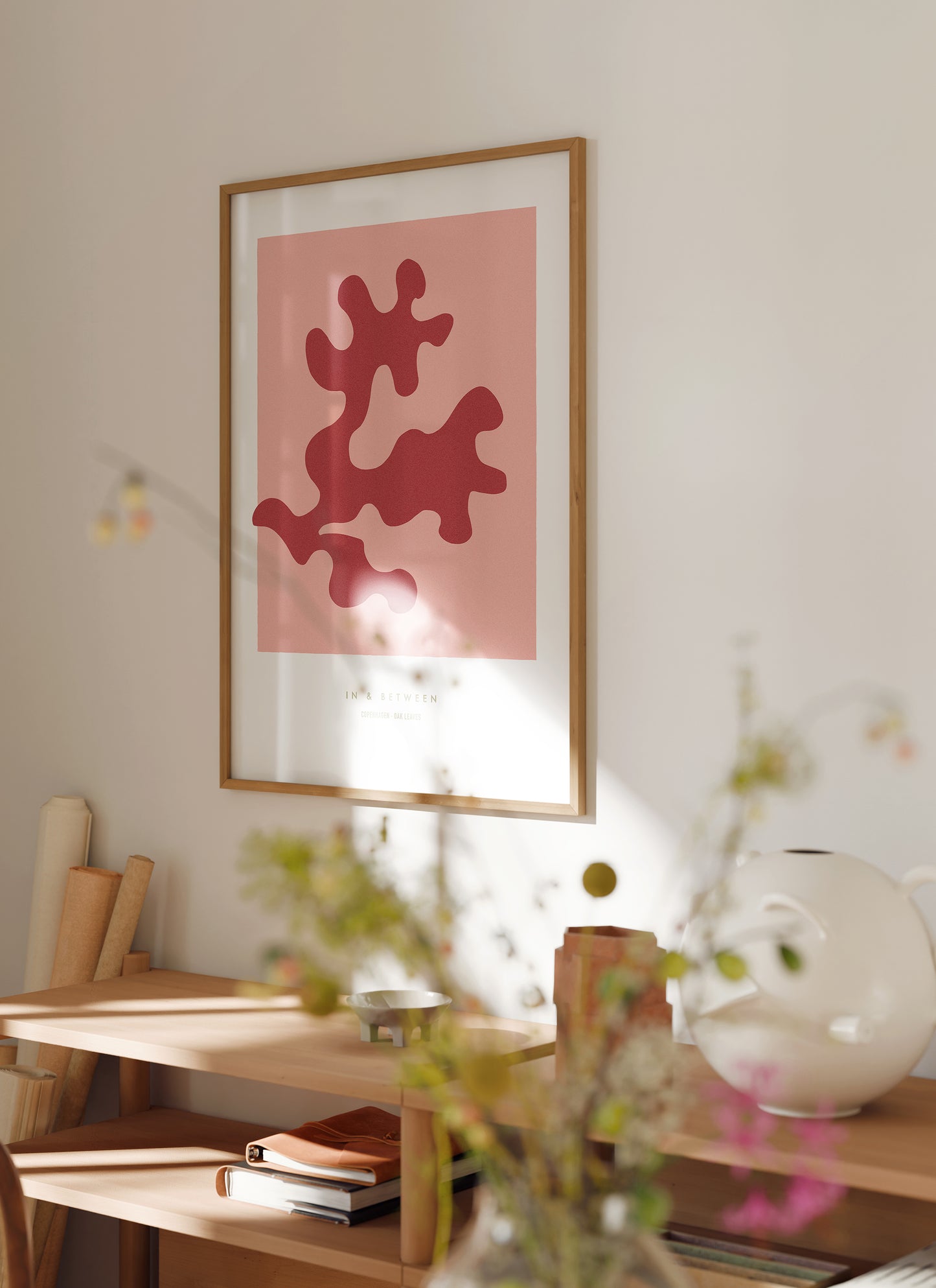 Art print of strawberry ice red oak leaf and background in natural wooden frame hanging on wall in a room setting.