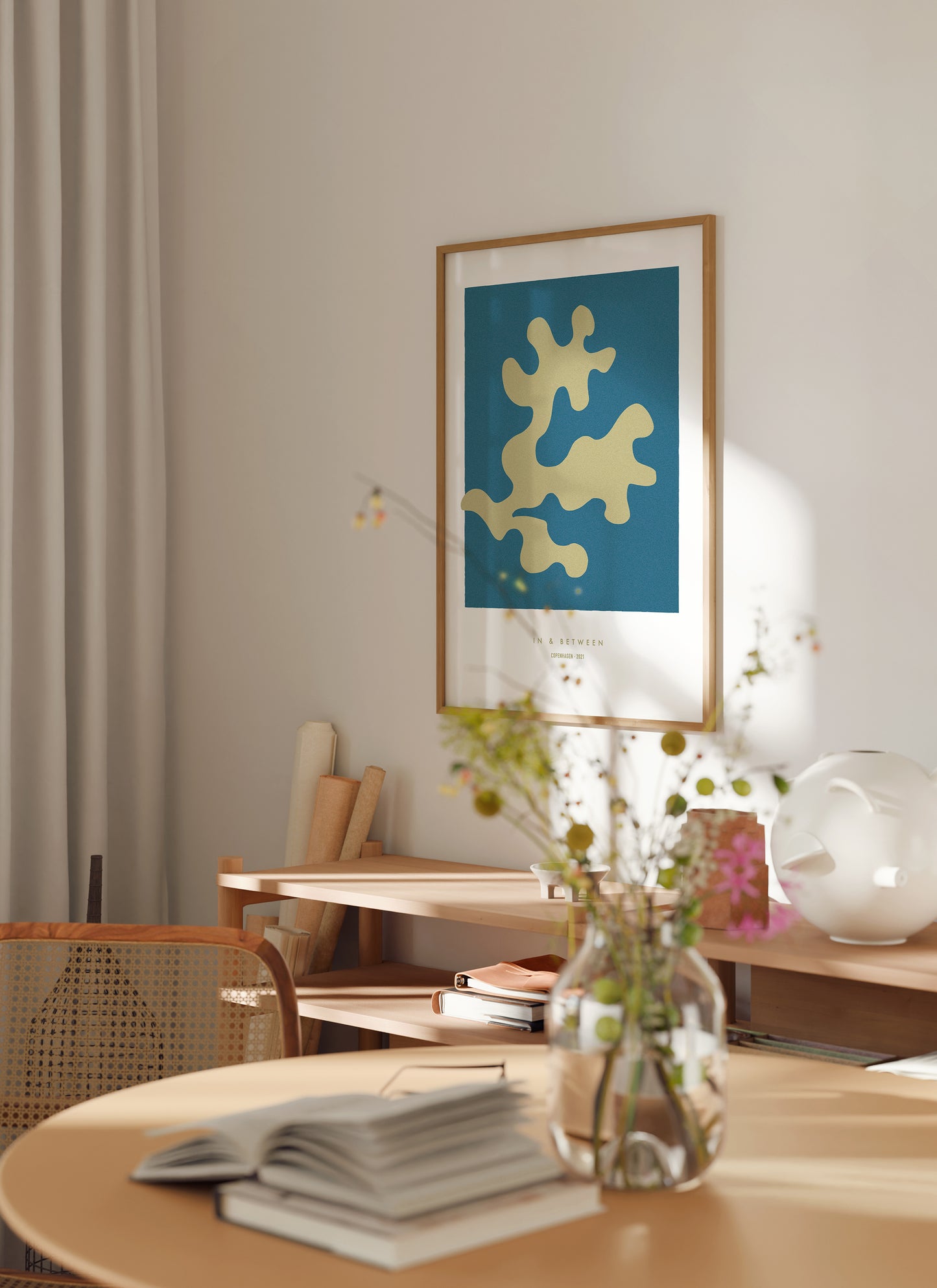 Lifestyle image of In and Between art print of golden oak leaf on dark blue background in natural wooden frame.
