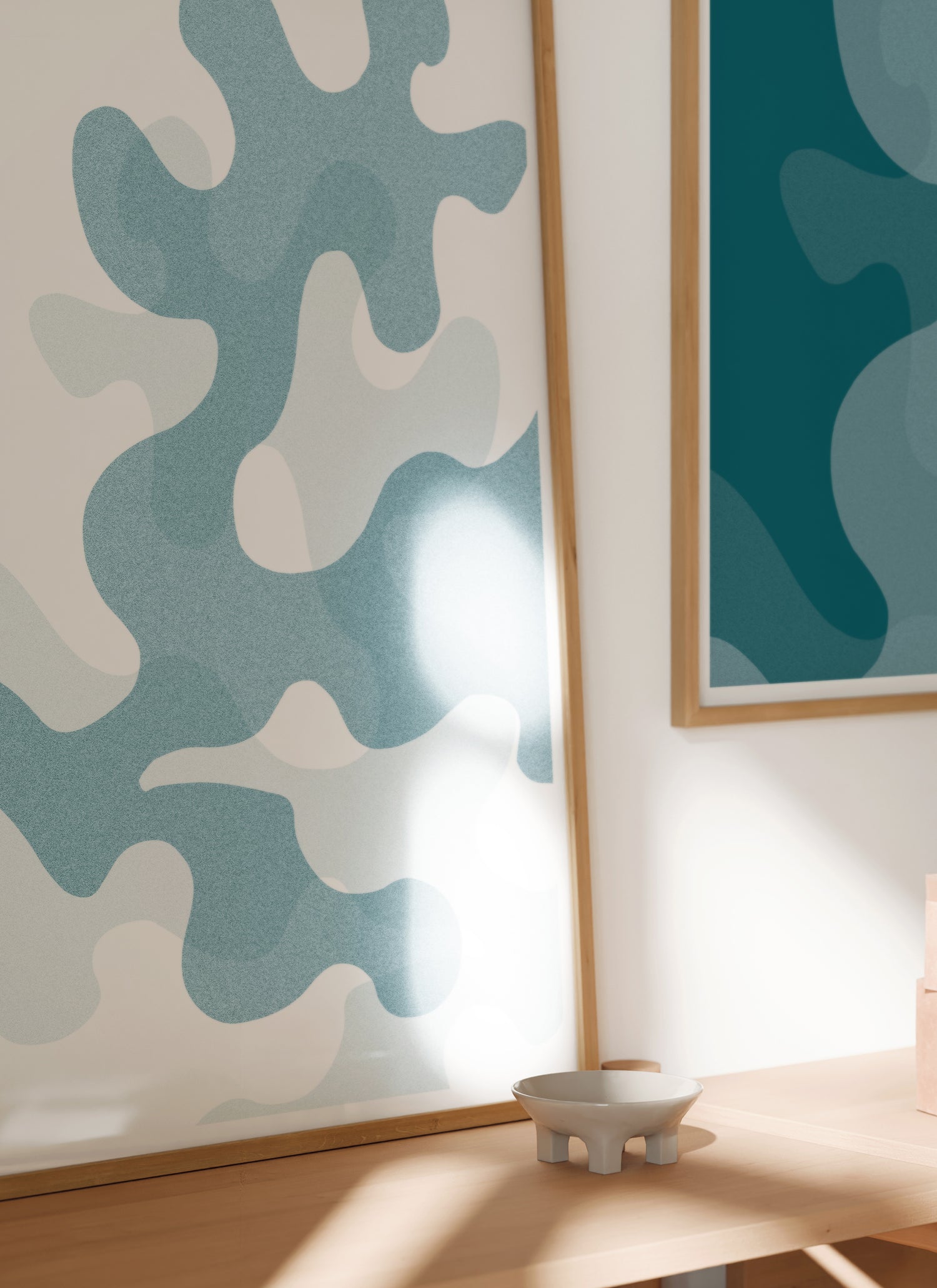 Lifestyle image of In and Between art print of large deep ocean blue oak leaf shapes in natural wooden frame.