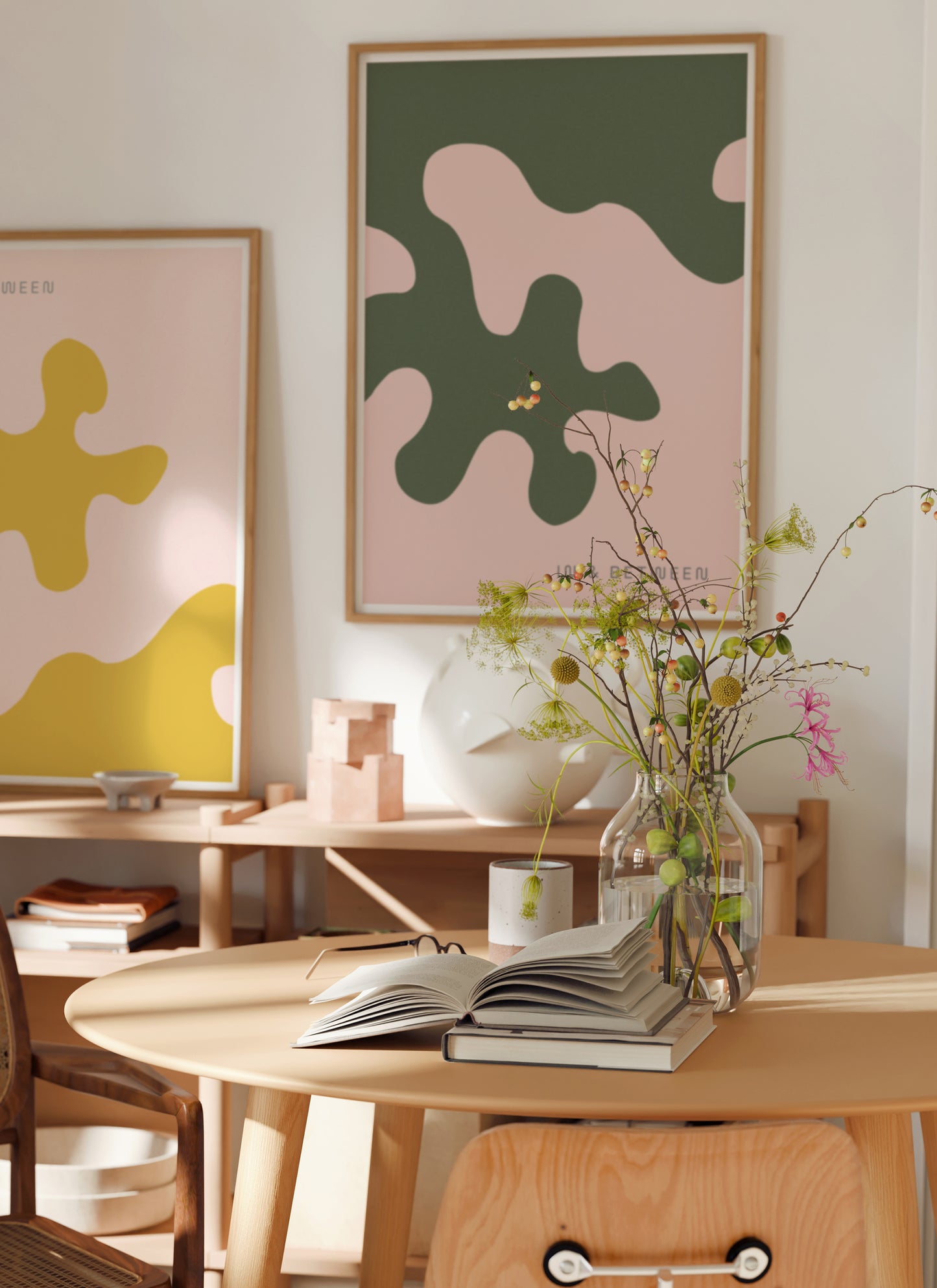 Lifestyle image with art print of large forest green oak leaf on soft peach background in natural wooden frame.