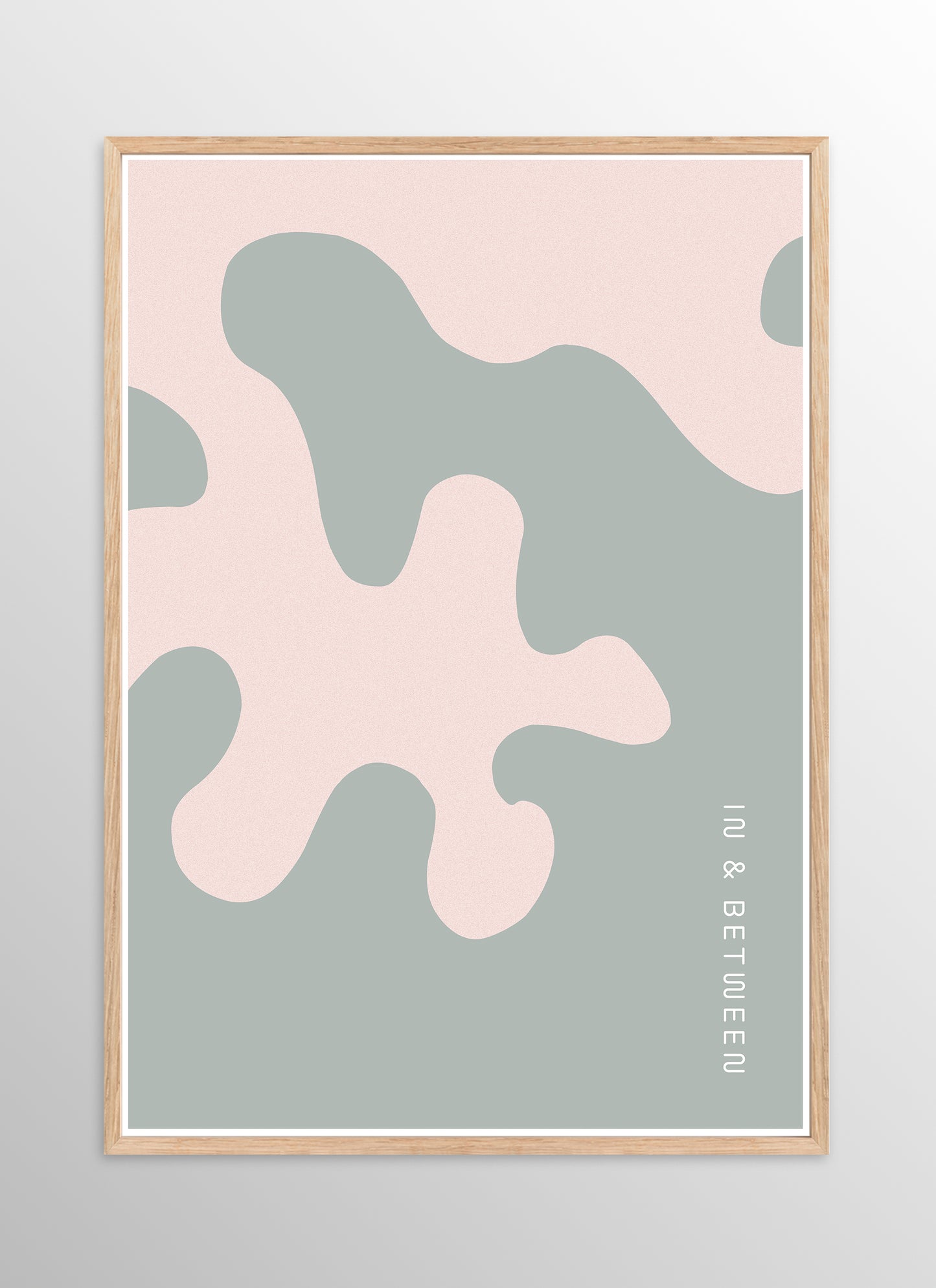 Art print of large soft pink oak leaf on grey background in natural wooden frame.