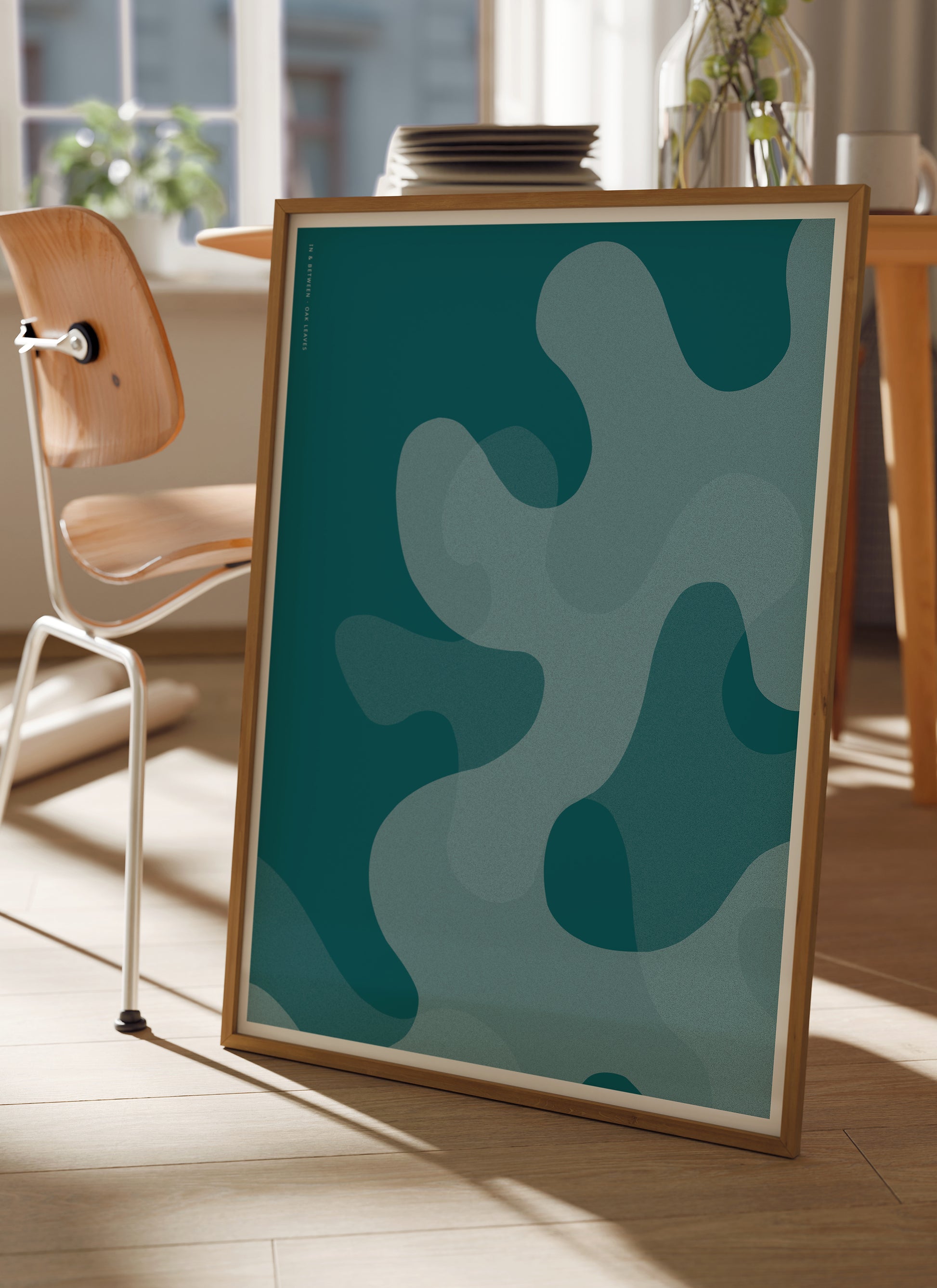 Lifestyle image of In and Between art print of large deep ocean blue oak leaf shapes in natural wooden frame.