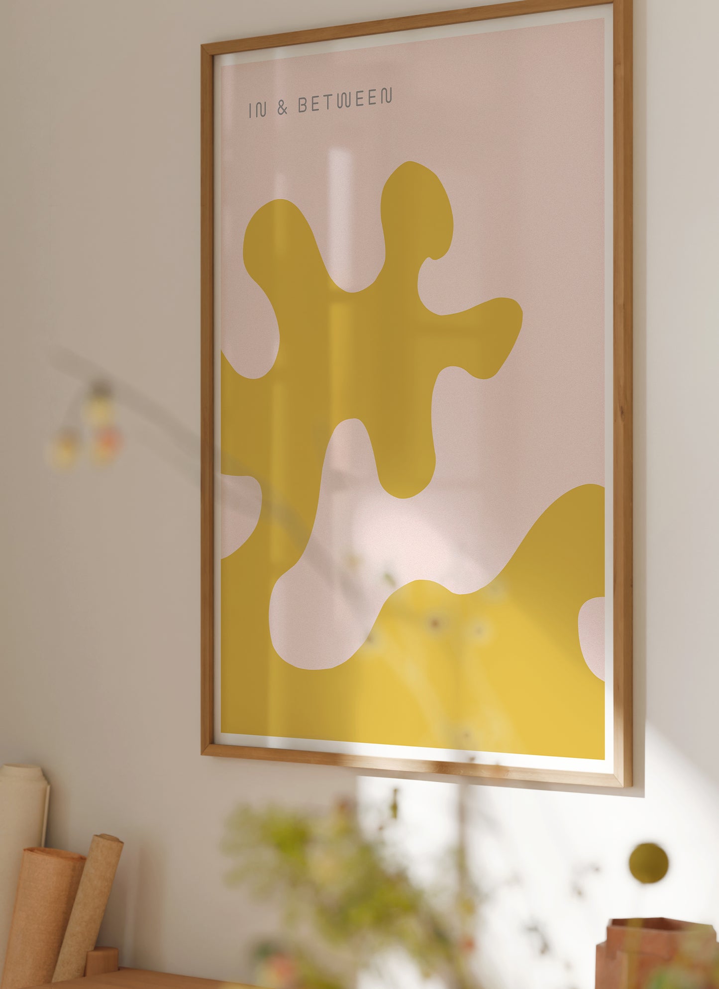 Lifestyle image with print of large oak leaf and background in light red yellow in natural wooden frame.