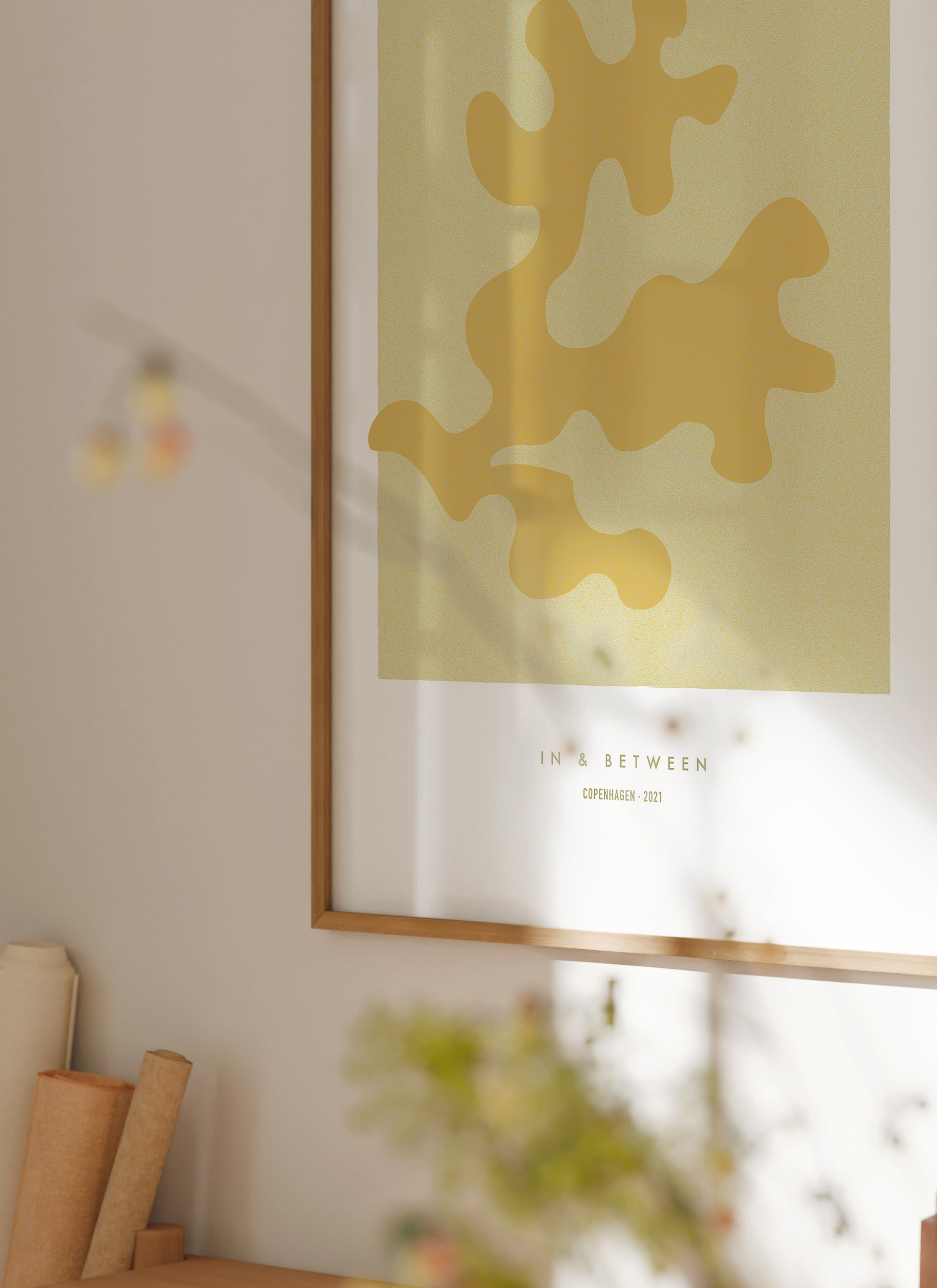 Lifestyle image with art print of maple oak leaf and background in natural wooden frame.