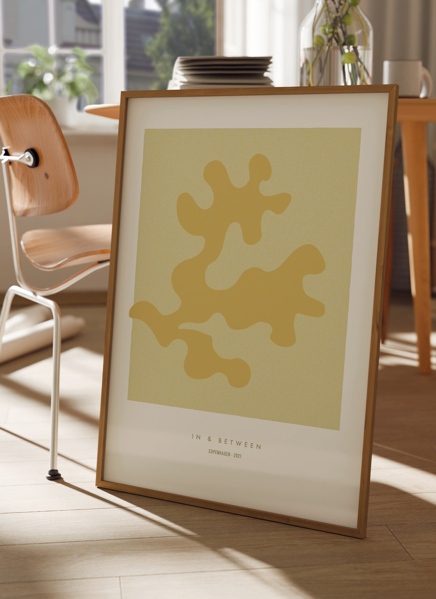 Lifestyle image with art print of maple oak leaf and background in natural wooden frame.