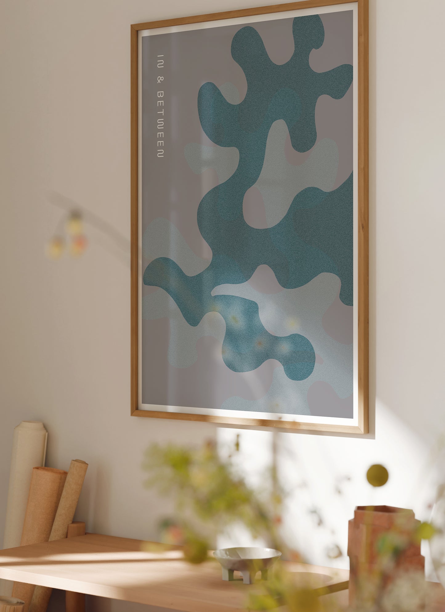 Lifestyle image with art print of oak leaves and background in grey shades in natural wooden frame.