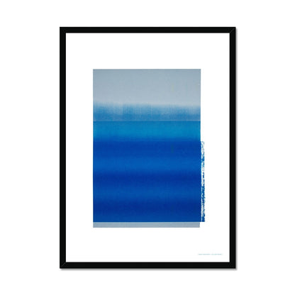 Black wood framed giclee print depicting a vibrant blue horizon within a wide white border. From being completely saturated at the bottom the pigments of colour slowly spread out upwards until it fades into space at the top like the horizon.