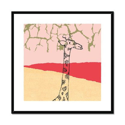 Art print of giraffe neck and head in black in a pale yellow and red landscape with light pink sky and golden branches reaching from above in a black wooden frame.